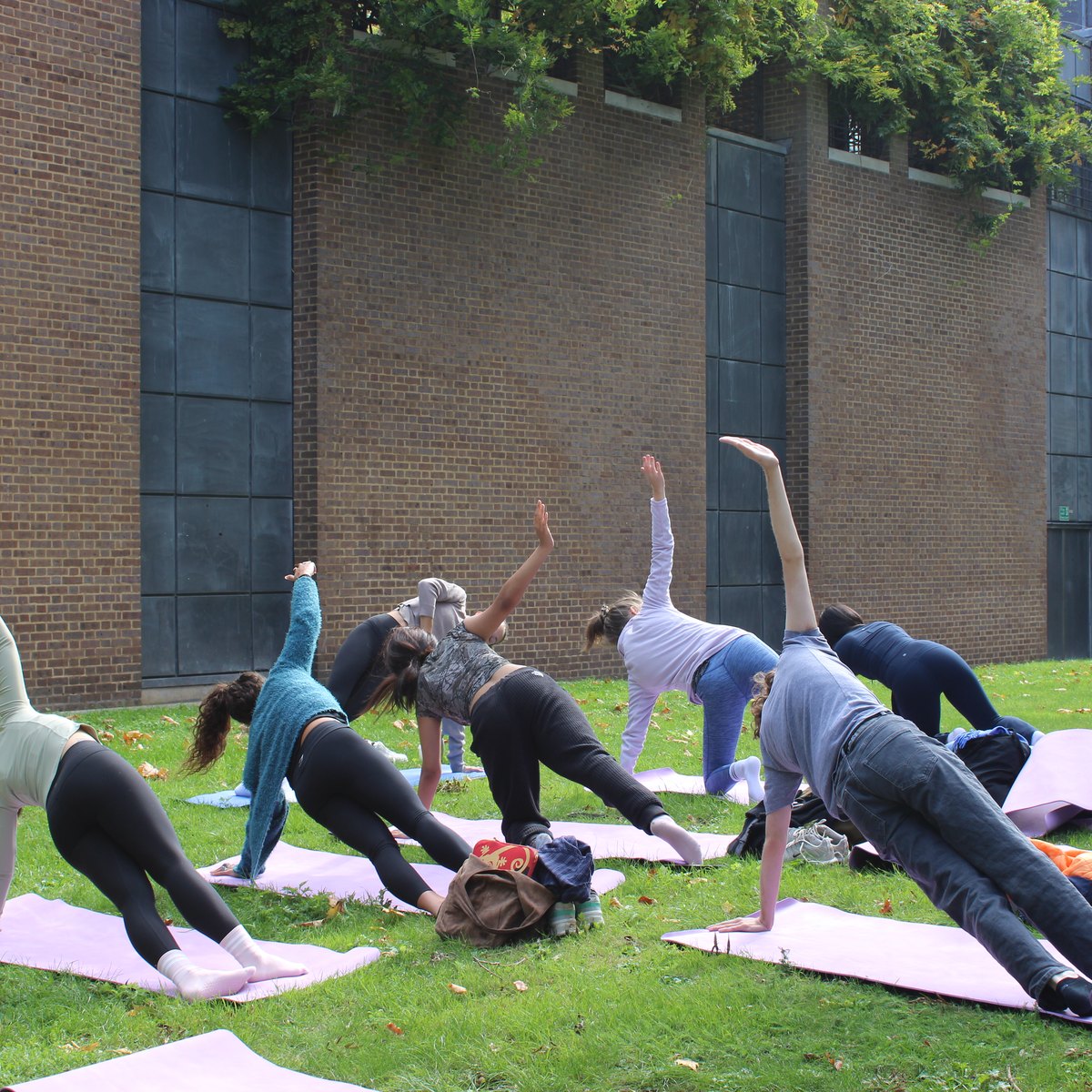 An outdoor yoga class on the grass at SOAS